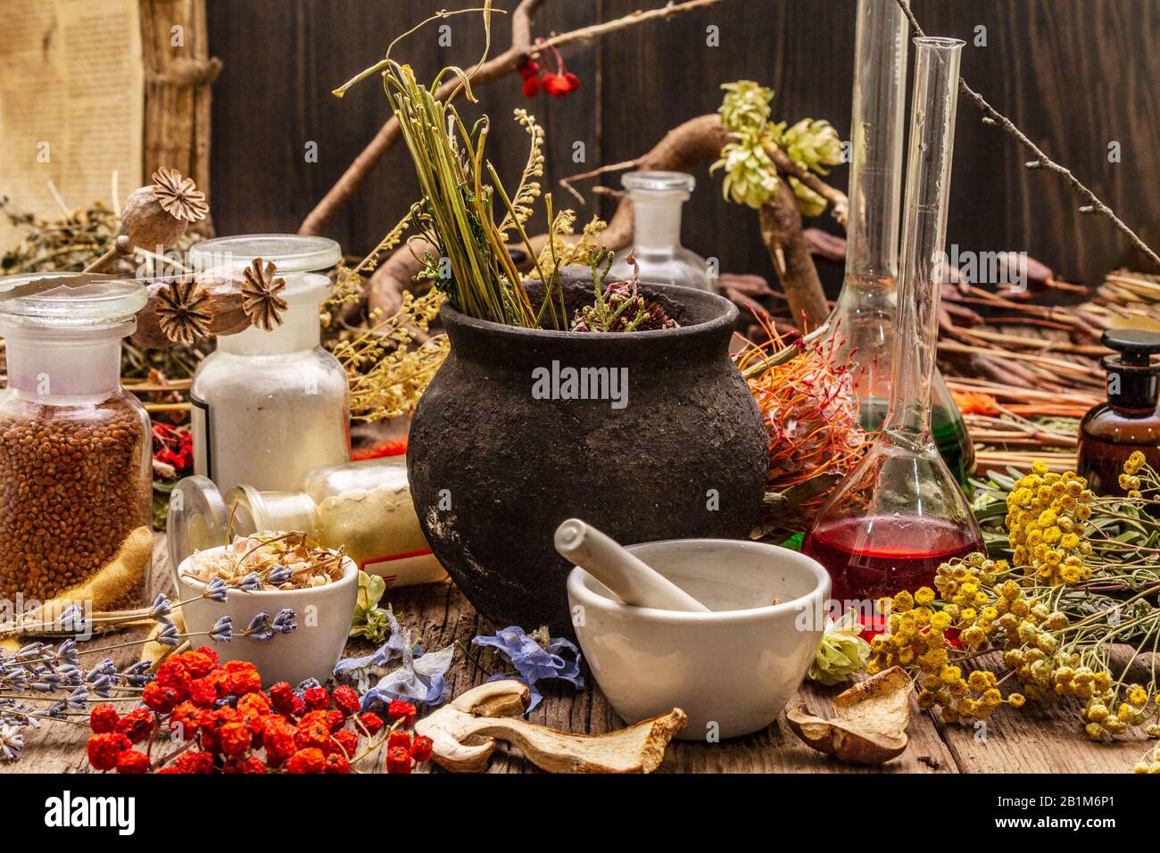 Laboratoire des sorcières. Équipement alchimique, traitement apothécaire. Mortier et pilon, bouteilles, poudres, herbes sèches. Concept Halloween, vieux panneaux en bois b Banque D'Images