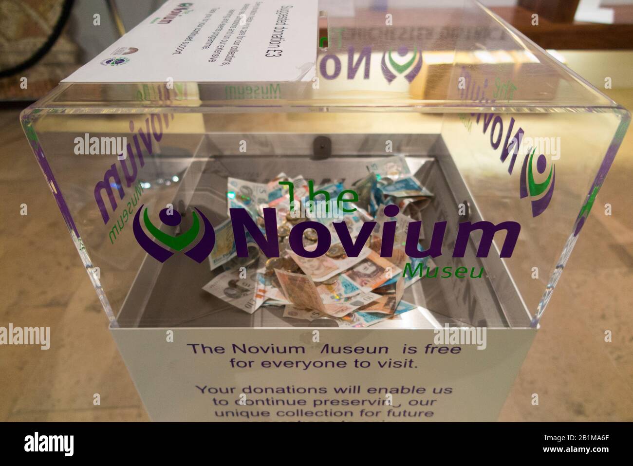 Boîte de don pour les visiteurs de faire don d'argent de charité au Musée Novium qui se dresse au-dessus des restes d'une salle de bain romaine à Chichester, West Sussex. Angleterre. ROYAUME-UNI (114) Banque D'Images