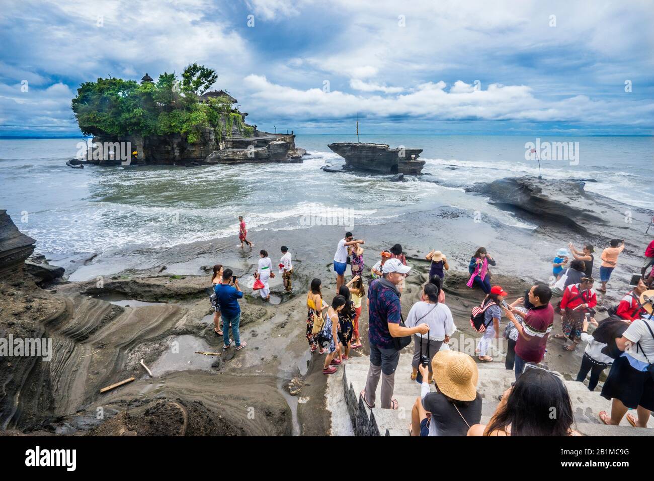 Visiteurs à Tanah Lot, une formation de roches au large de l'île indonésienne de Bali, où se trouve un ancien temple de pèlerinage hindou Pura Tanah Lot, Bali, Indonésie Banque D'Images
