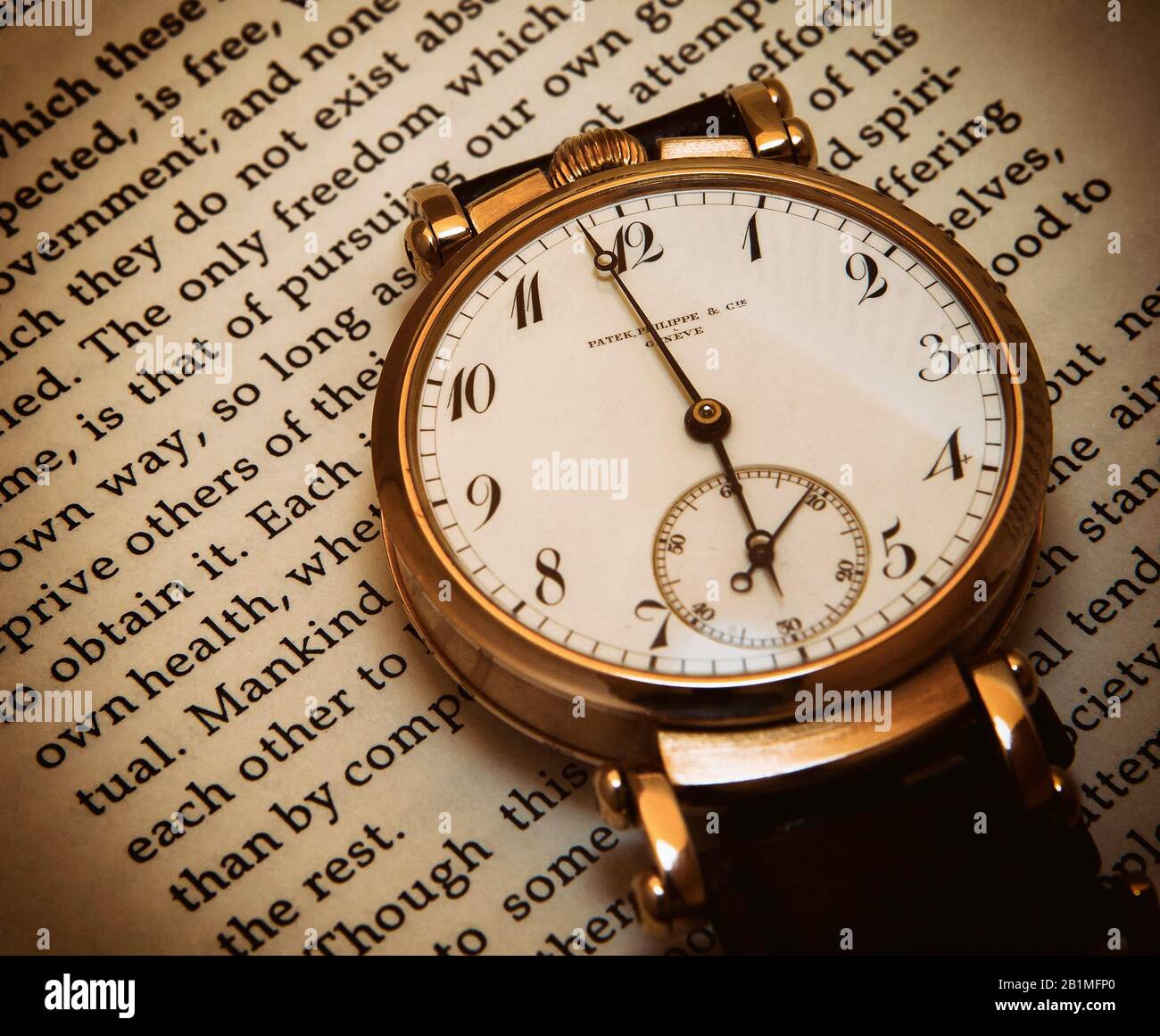 Temps libre - montre-bracelet de luxe antique reposant sur le texte d'un passage du philosophe John Stuart Mill, Sur la liberté. Concept: Liberté, adaptation. Banque D'Images