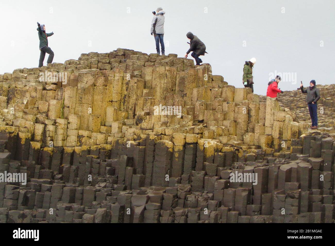 Des personnes au sommet de colonnes en pierre de basalte à Giant's Causeway Banque D'Images