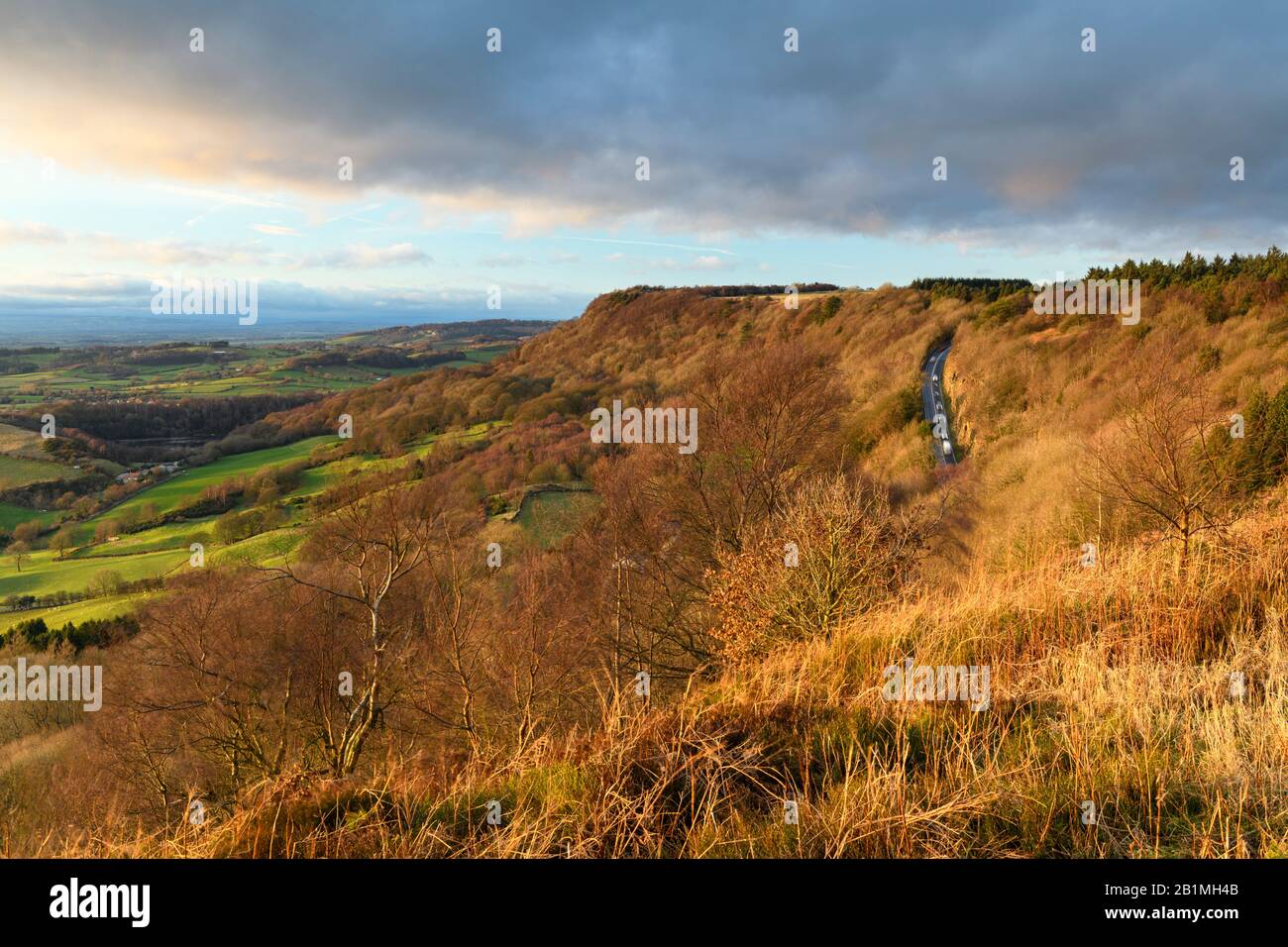 Magnifique vue panoramique sur les escarpements ensoleillées de Sutton Bank, la route escarpée, les terres agricoles et le ciel spectaculaire - La Cicatrice de Roulston, Yorkshire du Nord, Angleterre Royaume-Uni Banque D'Images