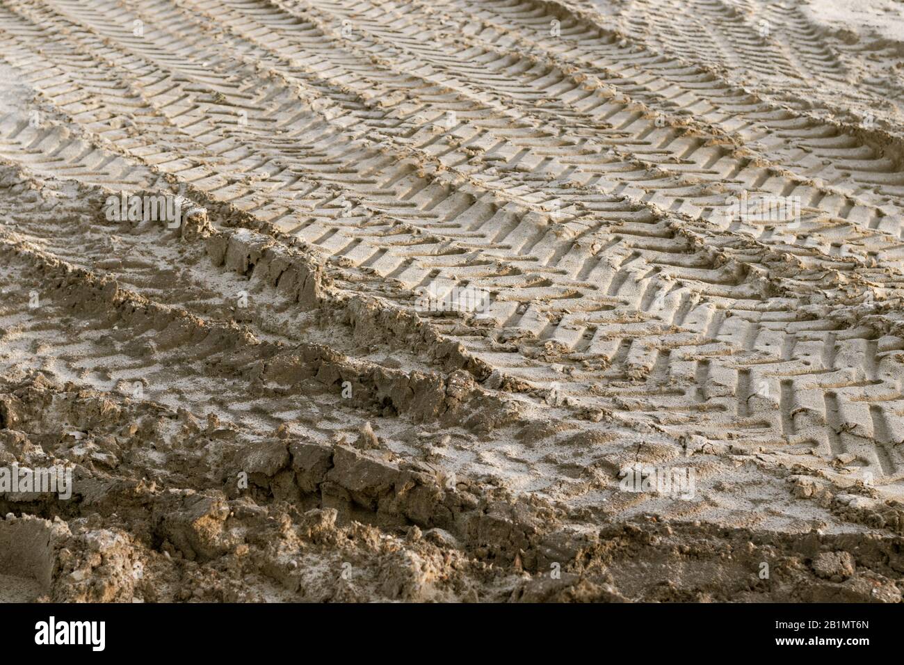 Des traces de pneus sur un terrain sablonneux sur un chantier de construction qui ressemble à un désert. Photo libre de droit. Banque D'Images