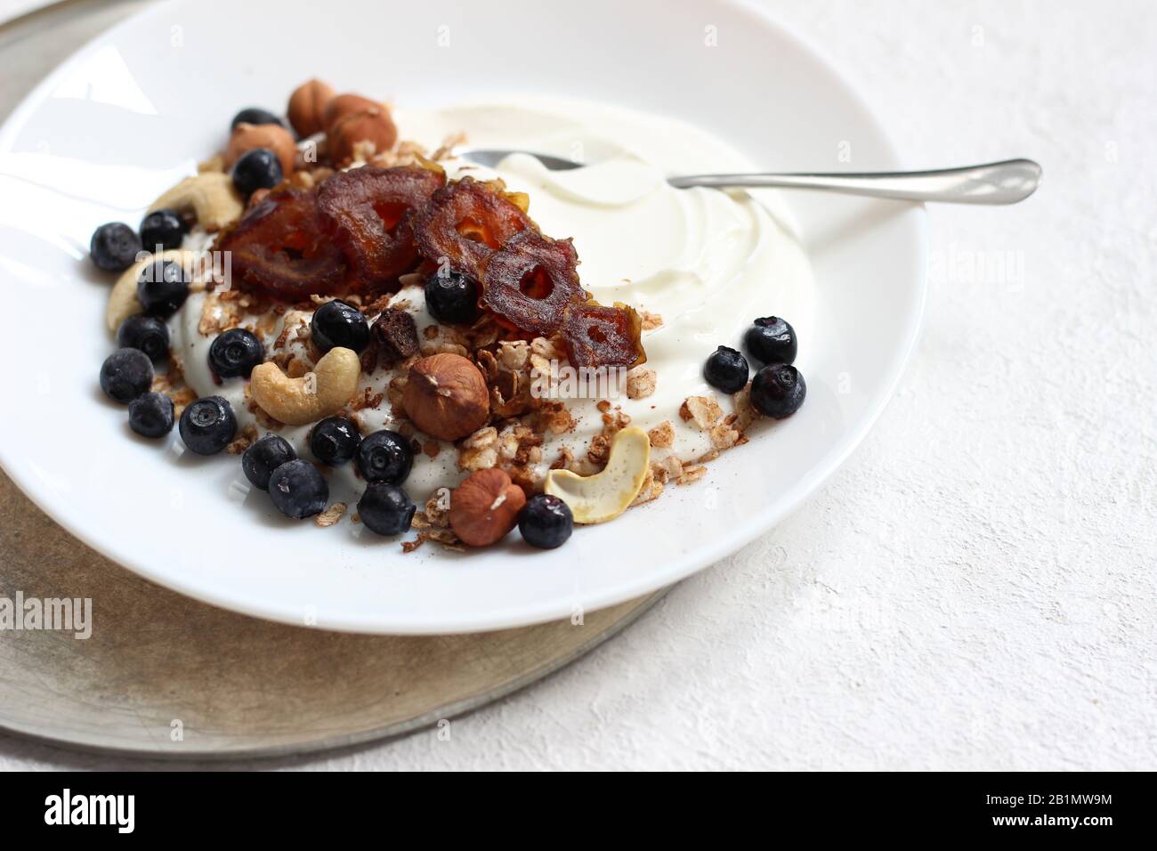 Petit Déjeuner. Gros plan de la plaque De Yaourt grec avec Granola, Noix, dattes et bleuets. Banque D'Images