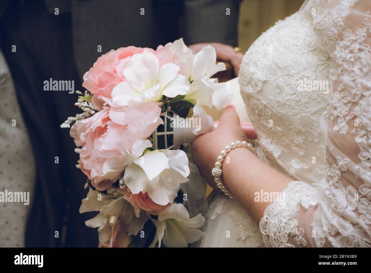 Un bouquet de fleurs mariées est tenu par une mariée le jour de son mariage Banque D'Images