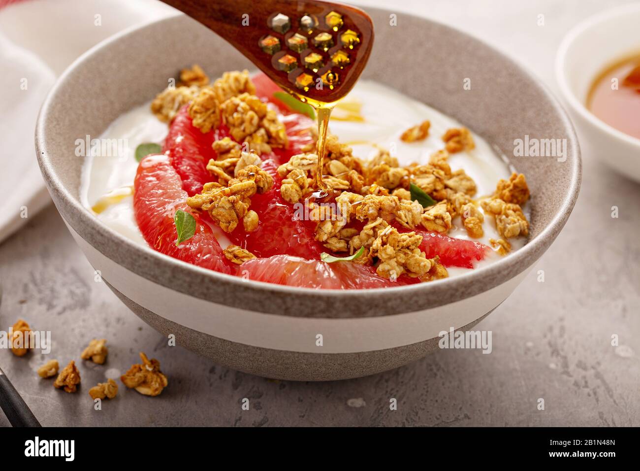 Bol de yougurt avec tranches de pamplemousse et granola Banque D'Images