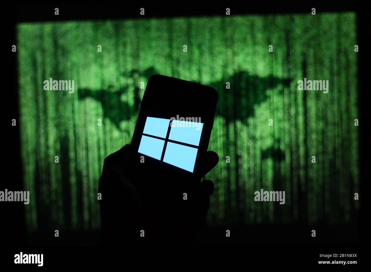 Logo Microsoft Windows 10 affiché sur l'écran du smartphone avec une carte du monde de type matrice visible floue en arrière-plan Banque D'Images