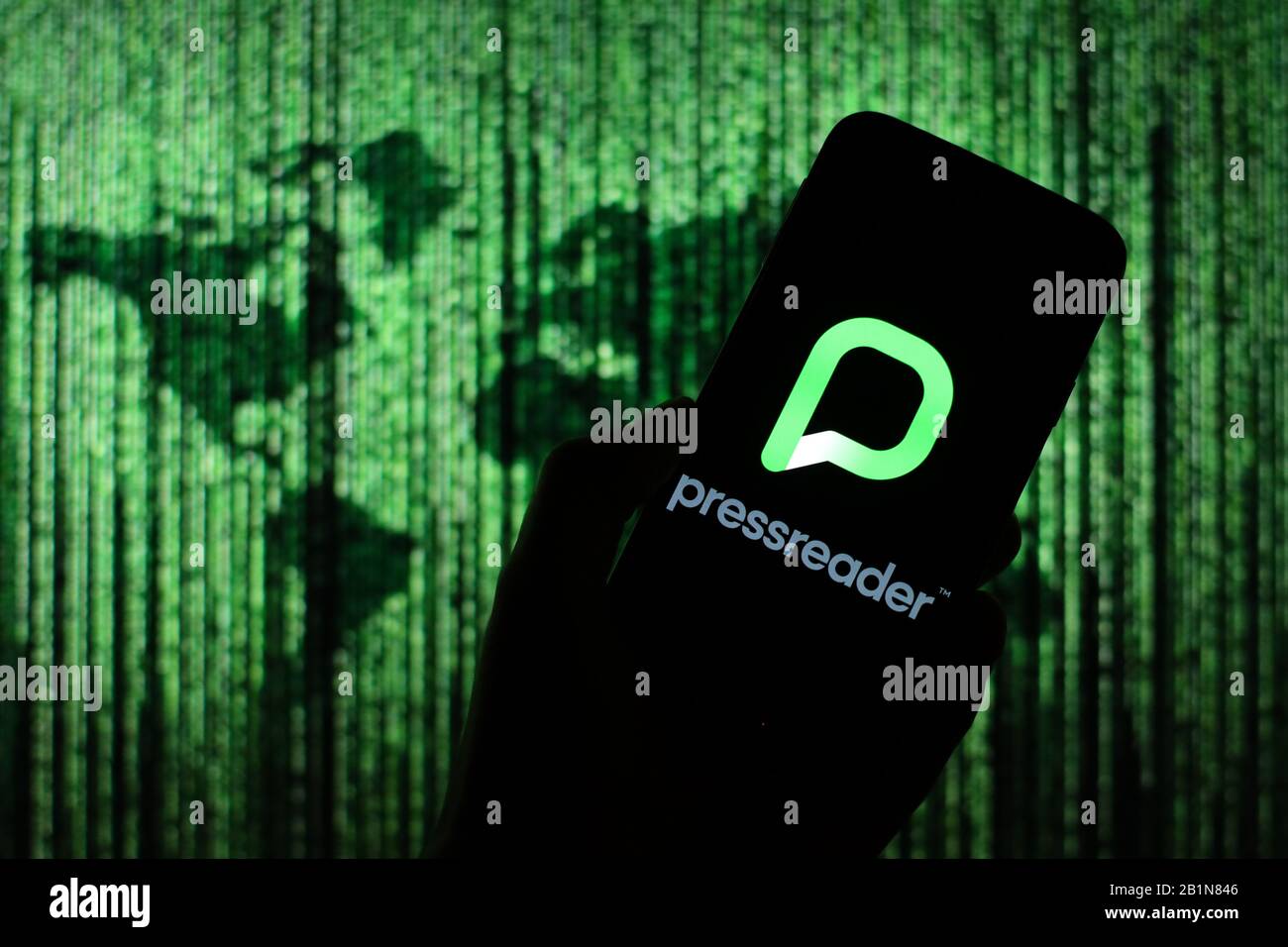 Le logo de l'application PressReader s'affiche sur l'écran du smartphone avec une carte du monde de type matrice visible floue en arrière-plan Banque D'Images