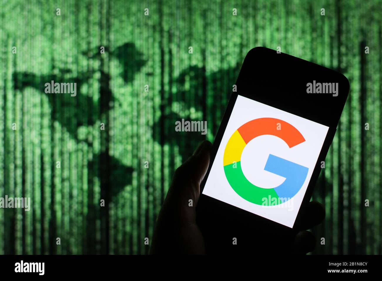 Le logo de Google Company s'affiche sur l'écran du smartphone avec une carte du monde de type matrice visible floue en arrière-plan Banque D'Images