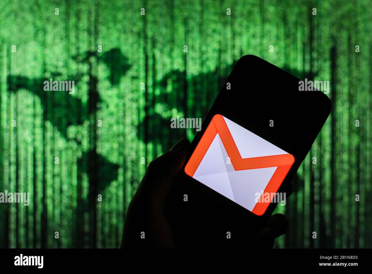 Logo Google Gmail affiché sur l'écran du smartphone avec une carte du monde de type matrice visible floue en arrière-plan Banque D'Images