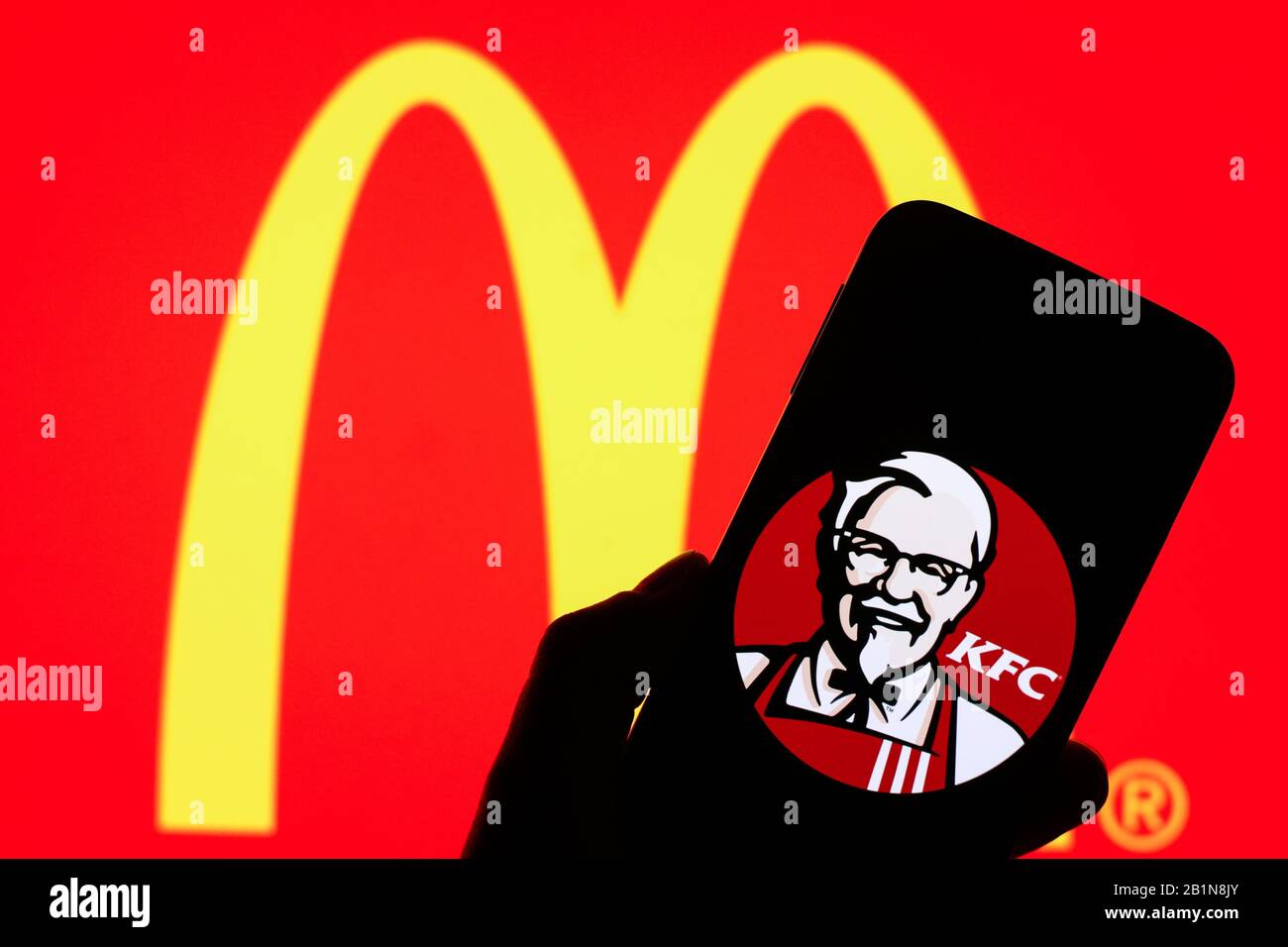 Le logo KFC affiché sur l'écran du smartphone avec le logo Macdonald est flou en arrière-plan Banque D'Images
