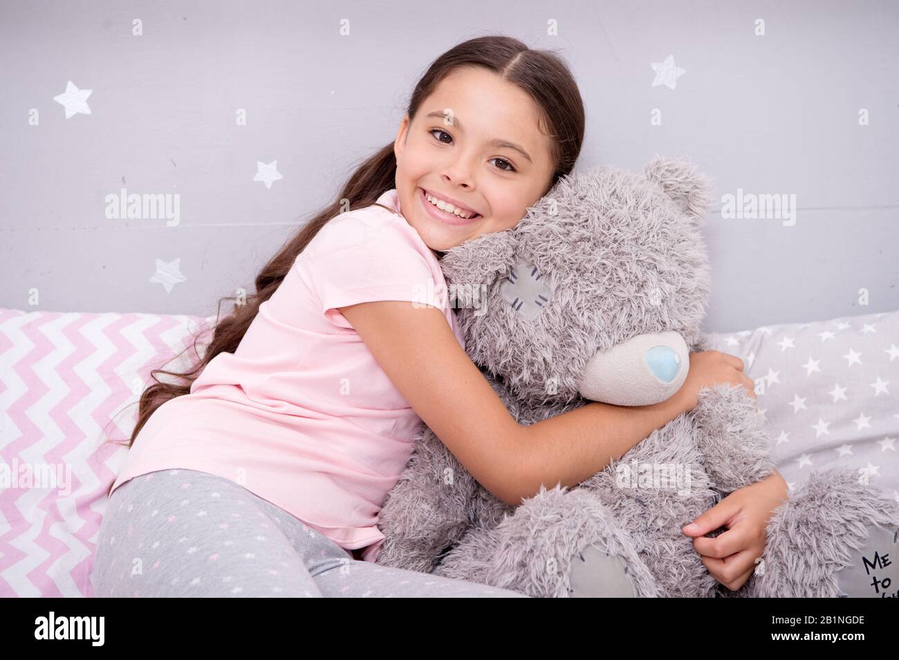 Mon meilleur ami. Jouet préféré. Concept d'amour pur. Fille enfant hug ours  en peluche dans sa chambre. Agréable séjour dans une chambre confortable.  Fille enfant long cheveux mignon pyjama se détendre et