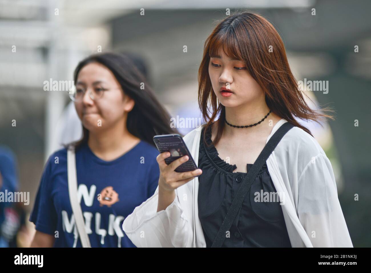 Wuhan: Une jeune fille utilisant son téléphone portable à la sortie de la station de métro Chuhe Hanije, rue Zhong Boi lu. Chine Banque D'Images