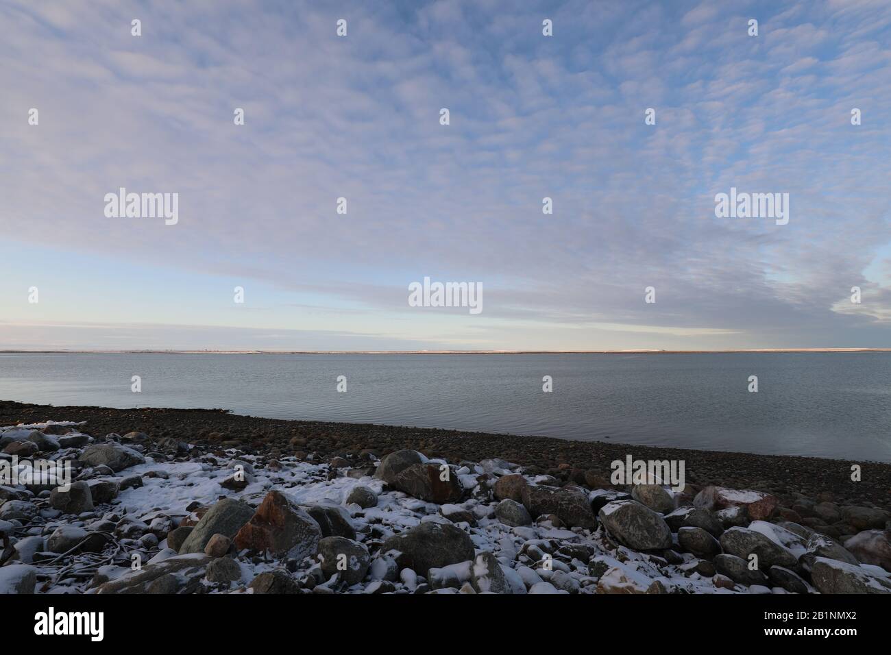 Paysage arctique plat à la fin de l'automne avec neige au sol et ciel bleu avec des nuages moelleux, près d'Arviat Nunavut Canada Banque D'Images