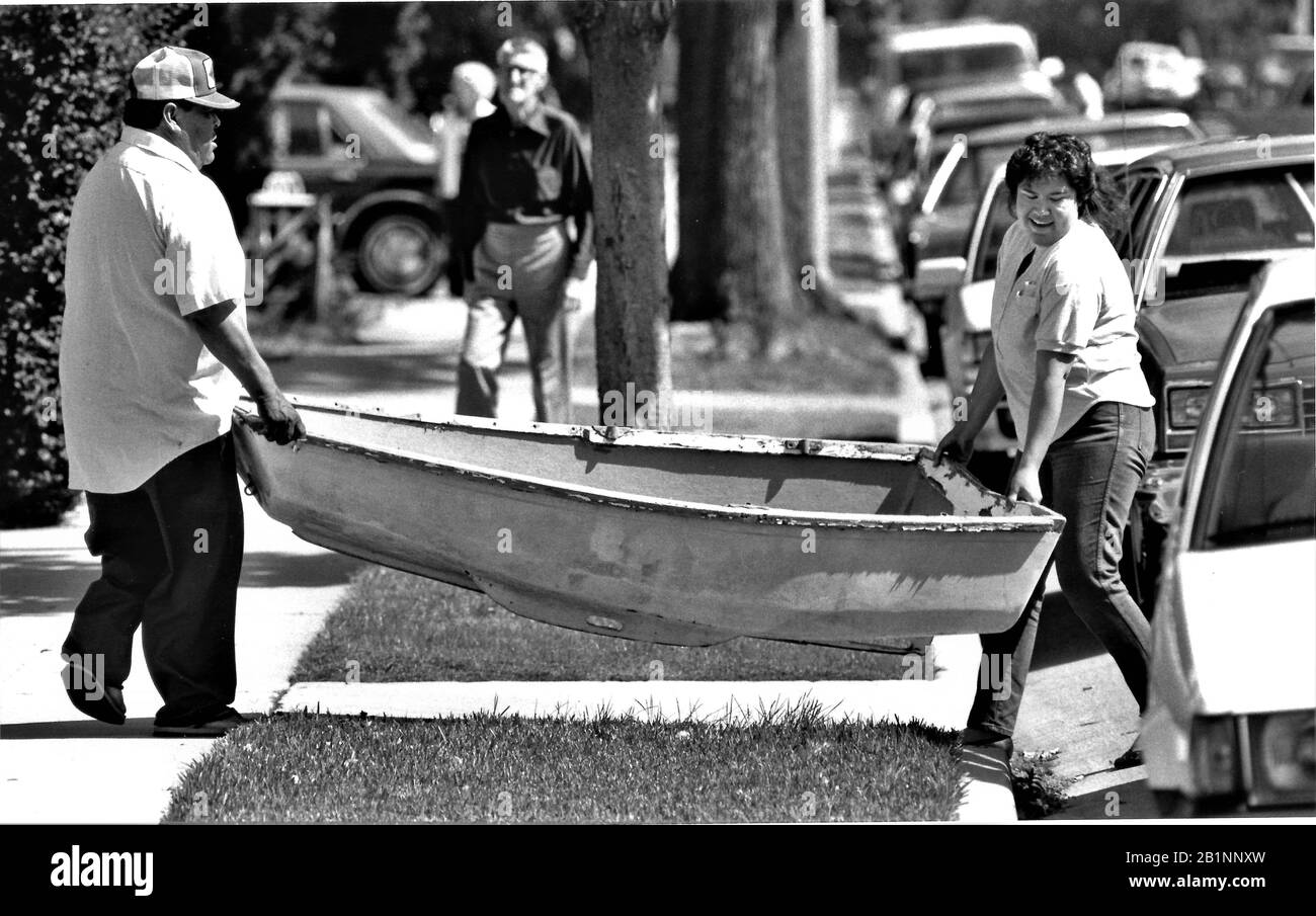 couple prenant à la maison le petit bateau de rangée qu'ils ont acheté à une vente de garage Banque D'Images