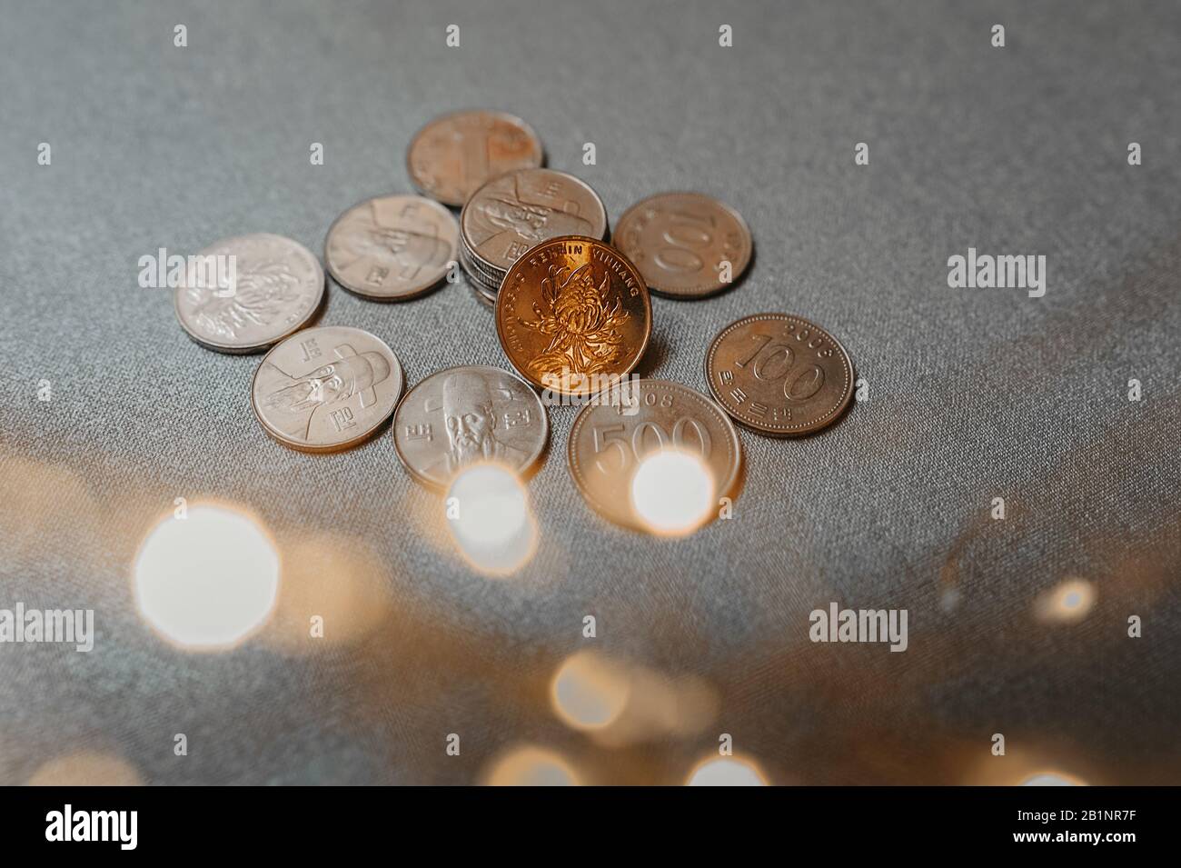 Poignée de pièces chinoises argentées de différentes valeurs sur un fond textile uniforme dans la guirlande et bokeh d'elle Banque D'Images