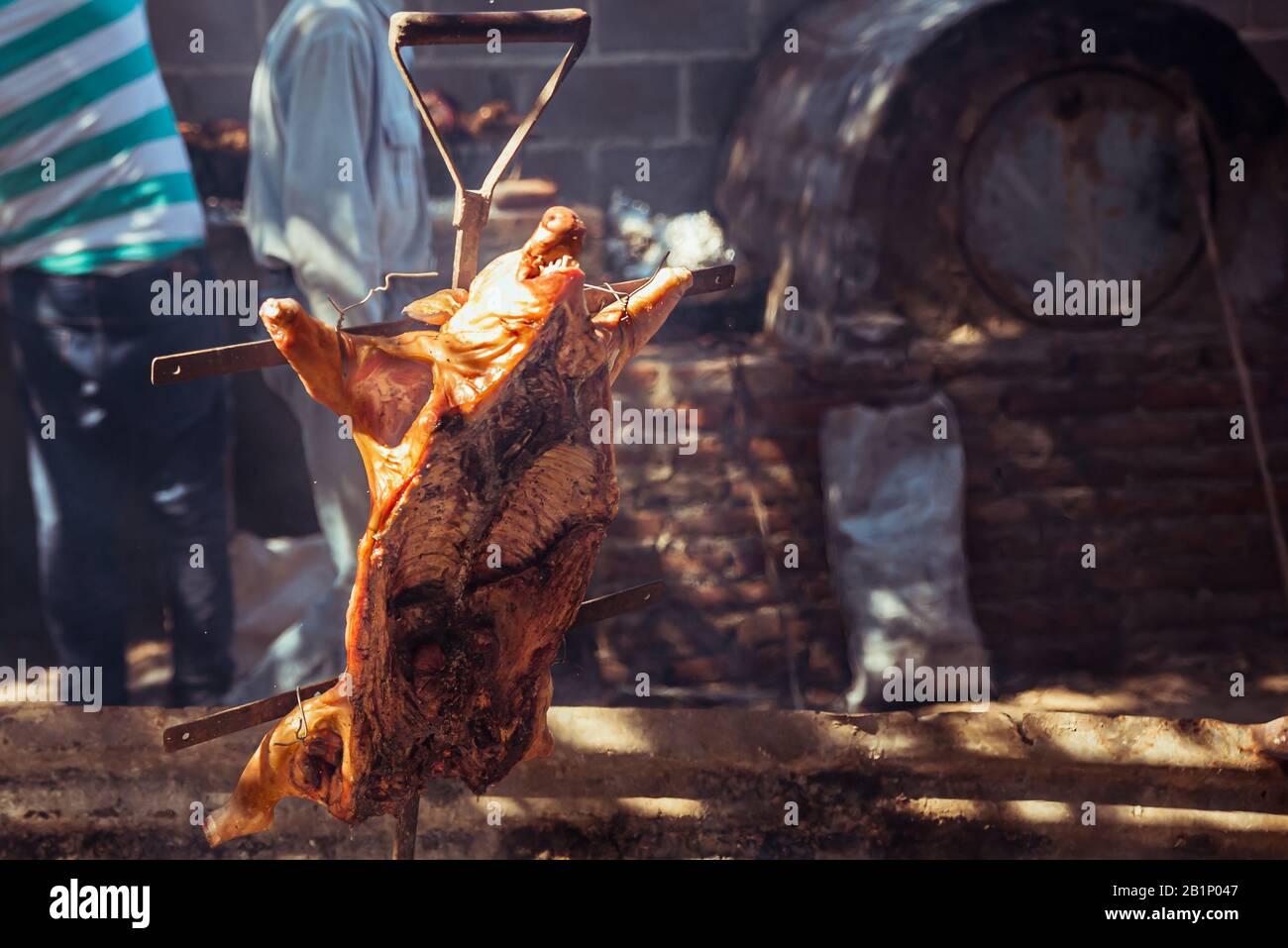 Cochon de succion traditionnel cuit sur le gril à charbon. Le petit cochon est grillé dans son ensemble sur un feu ouvert. Cochon organique sur la broche. Banque D'Images