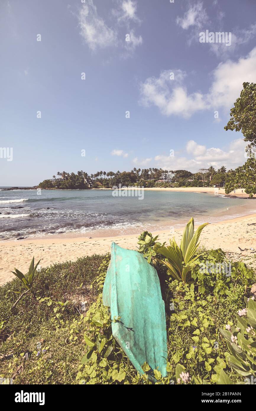 Photo stylisée de couleur rétro d'une plage tropicale avec un petit bateau. Banque D'Images
