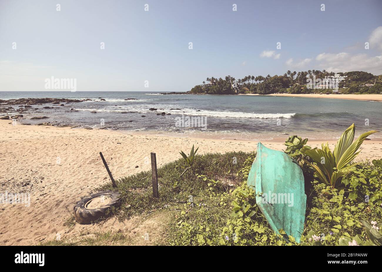 Photo stylisée de couleur rétro d'une plage tropicale avec un petit bateau. Banque D'Images
