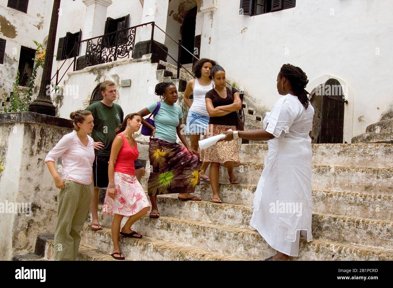Professeur d'université et étudiants en tournée au château d'Elmina en regardant les anciens quartiers d'esclaves, Ghana Banque D'Images