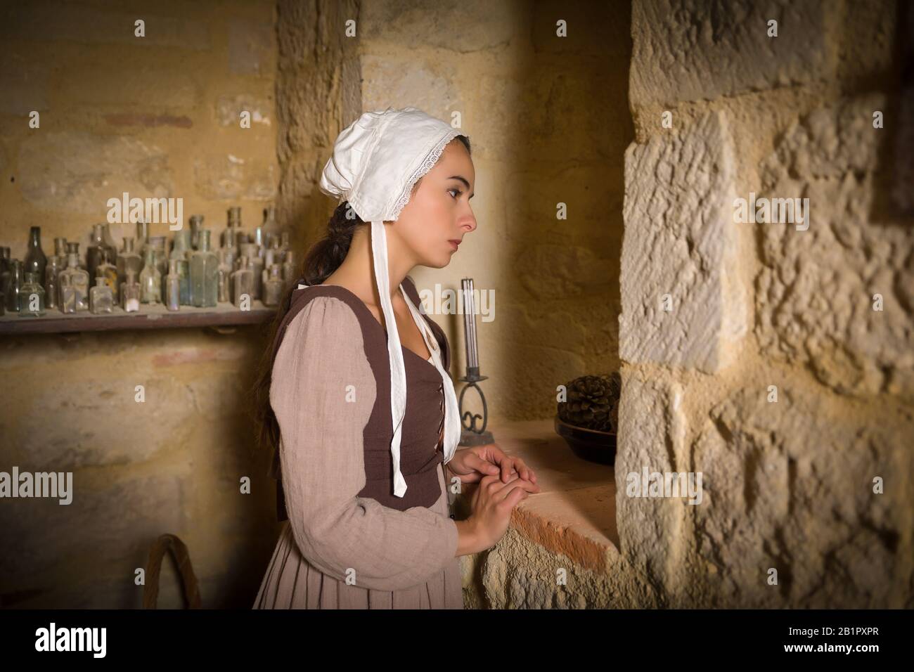 Style Vermeer portrait d'une jeune femme en costume à la Renaissance par la fenêtre d'un château français médiéval - avec des biens Banque D'Images