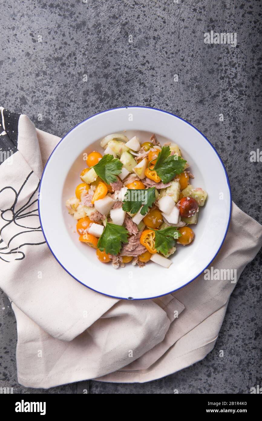 Salade de Nicoise avec thon, pomme, tomates cerises et sésame sur fond gris foncé. Cuisine française. Vue de dessus, espace de copie Banque D'Images