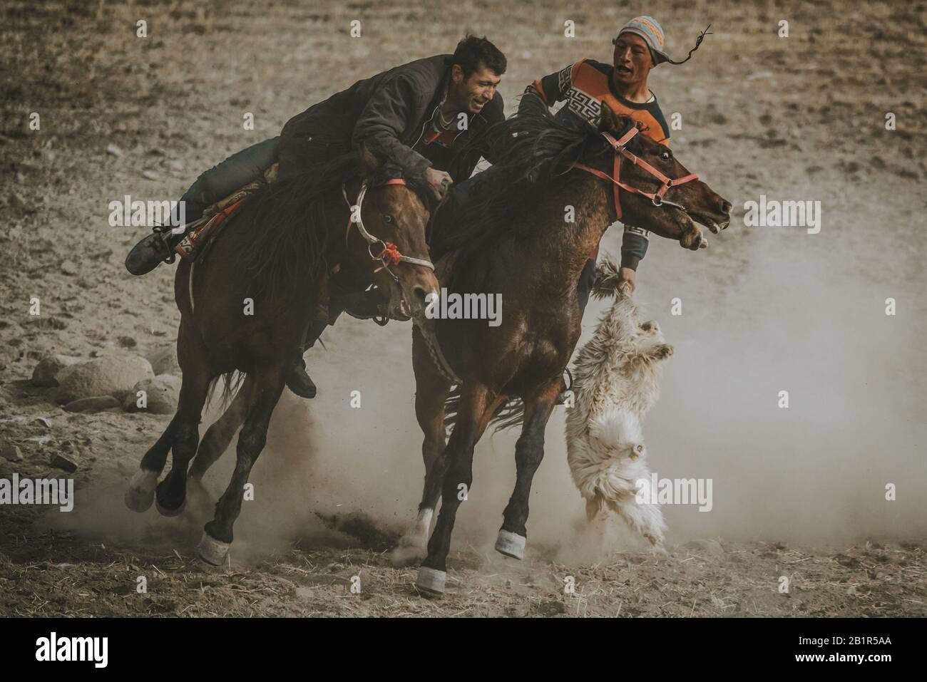 Tashkurgan, Chine - septembre 2019: Deux joueurs de Buzkashi au Tadjikistan pendant le sport traditionnel d'Asie centrale, équitation chevaux et essayer de place Banque D'Images