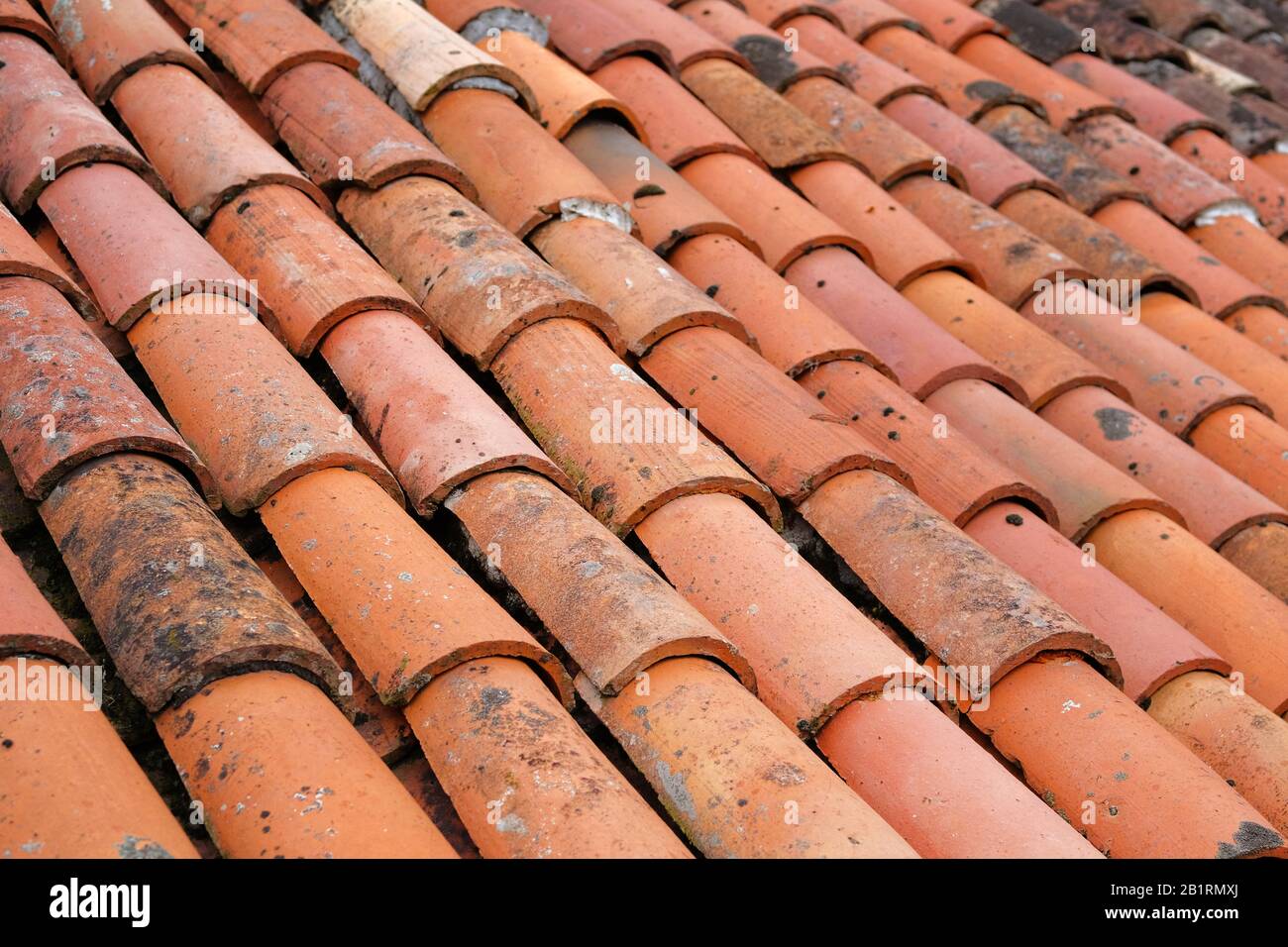 Vieilles tuiles en terre cuite sur le toit d'une maison rustique. Motif de tuiles arrière-plan de toit. Banque D'Images