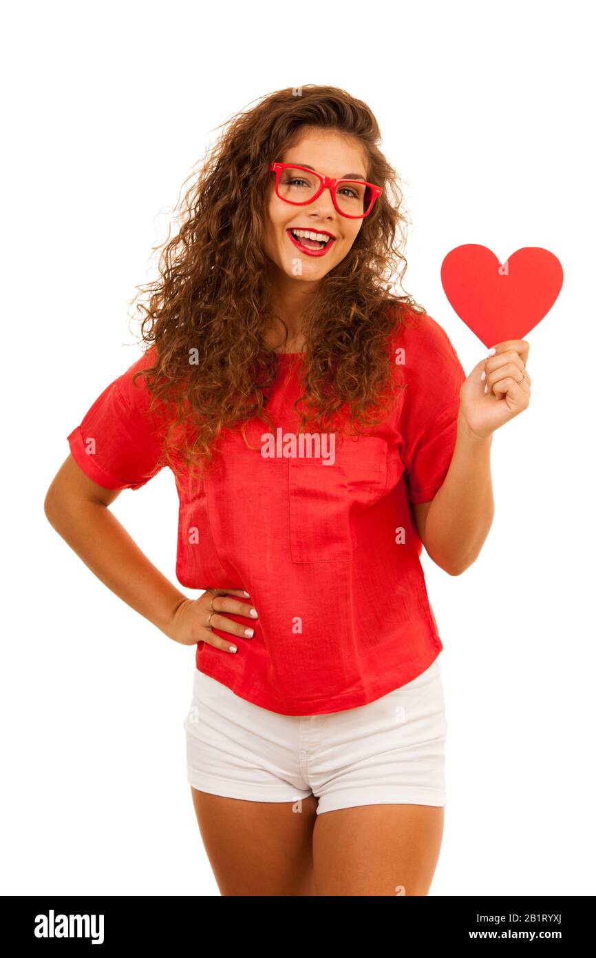 Belle jeune femme en rouge tenant un coeur pour la Saint Valentin isolé sur fond blanc Banque D'Images
