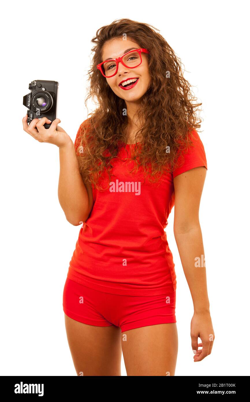 Femme en rouge tenant une caméra rétro isolé ovr fond blanc Banque D'Images