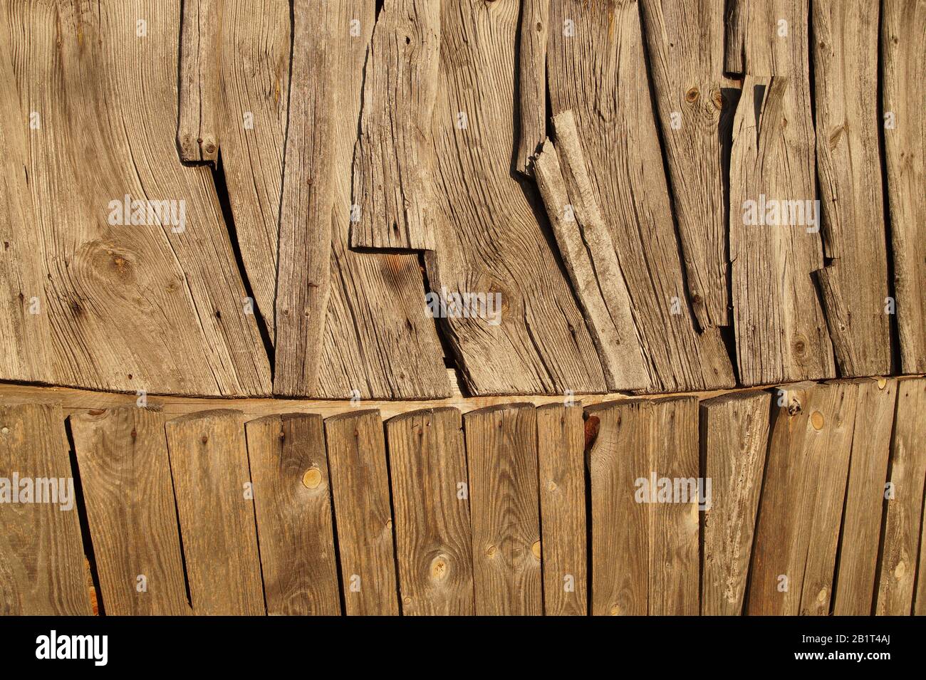 Un mur d'un vieux bâtiment en bois. Arrangement inhabituel de planches. Banque D'Images