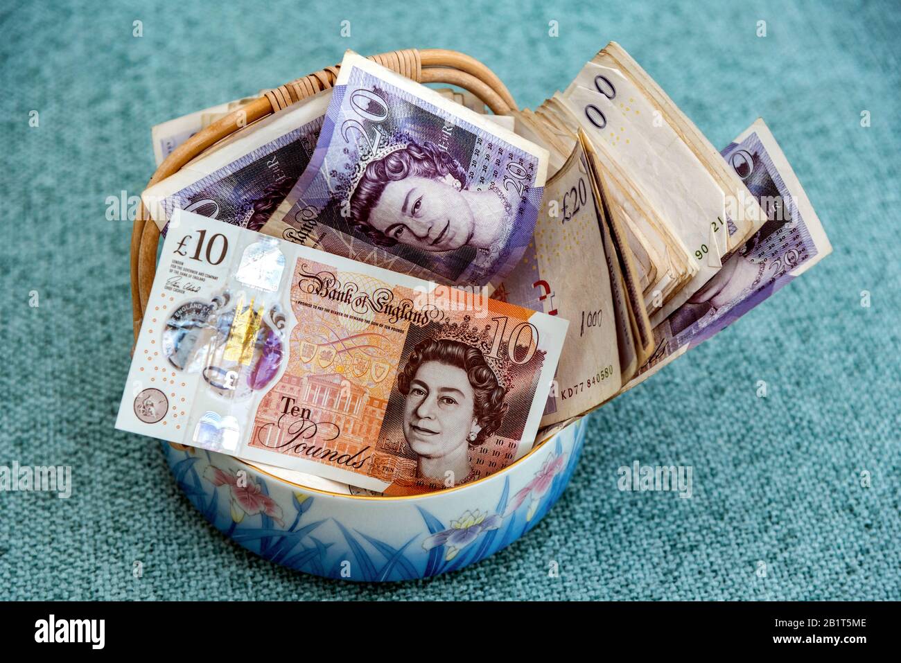 Un pot d'argent. Un plat rempli de billets britanniques. Banque D'Images