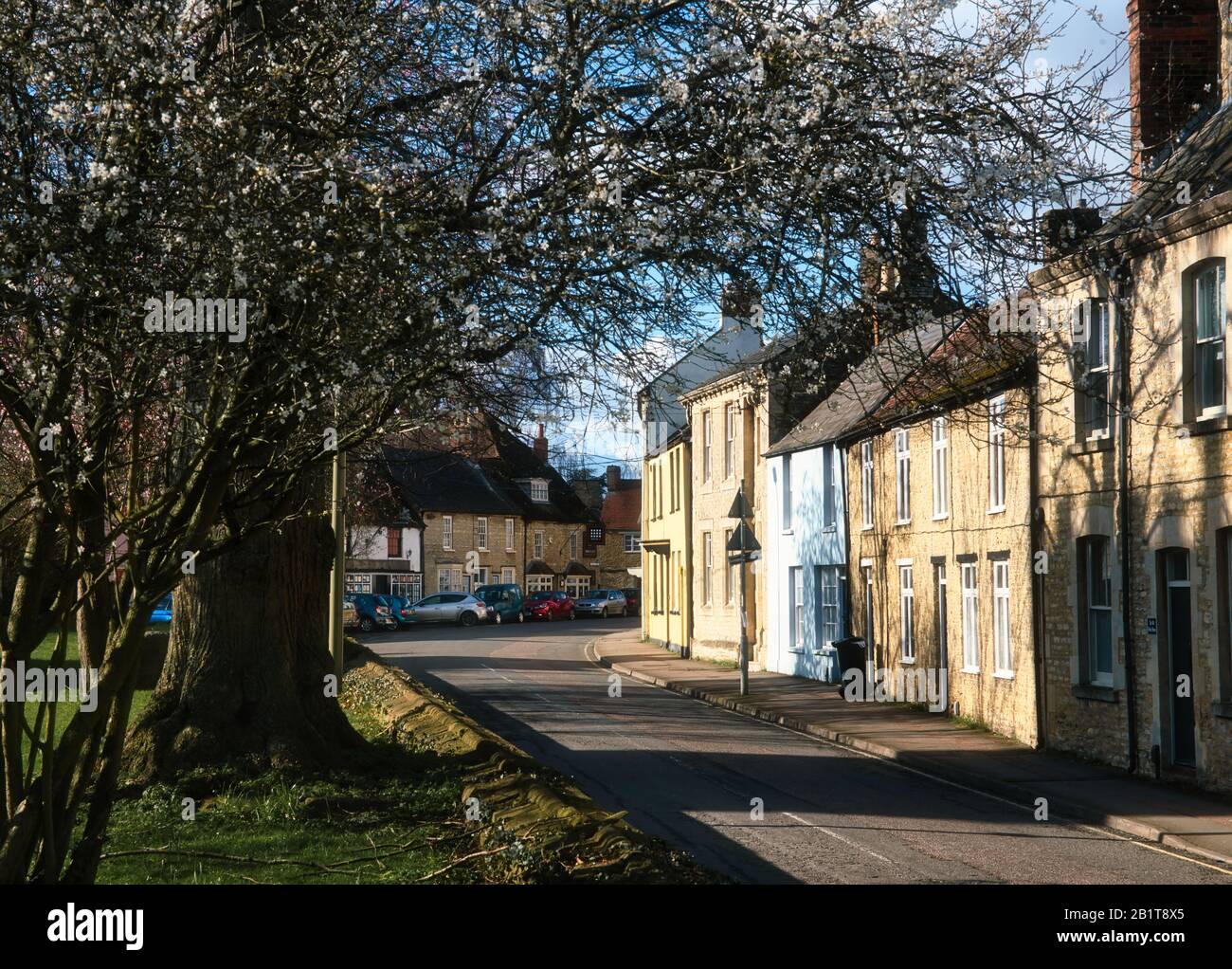 Church Street, Bicester, montrant une rangée de cottages multicolores du XIXe siècle en face de l'église. Tourné le jour ensoleillé, fin d'hiver. Banque D'Images