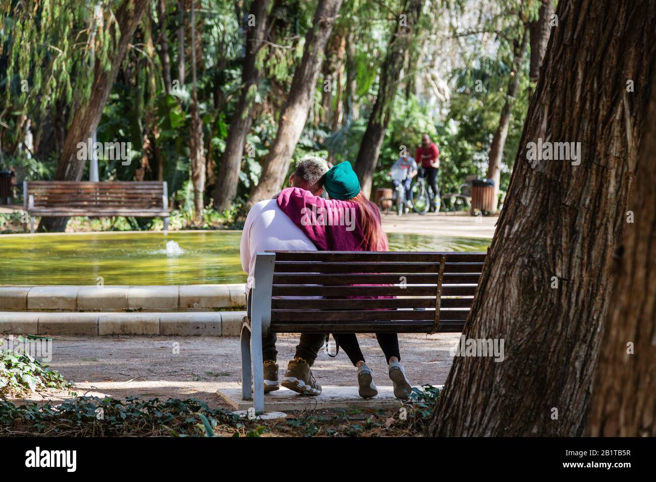 Jeune couple sur un banc de parc à Málaga, Espagne Banque D'Images