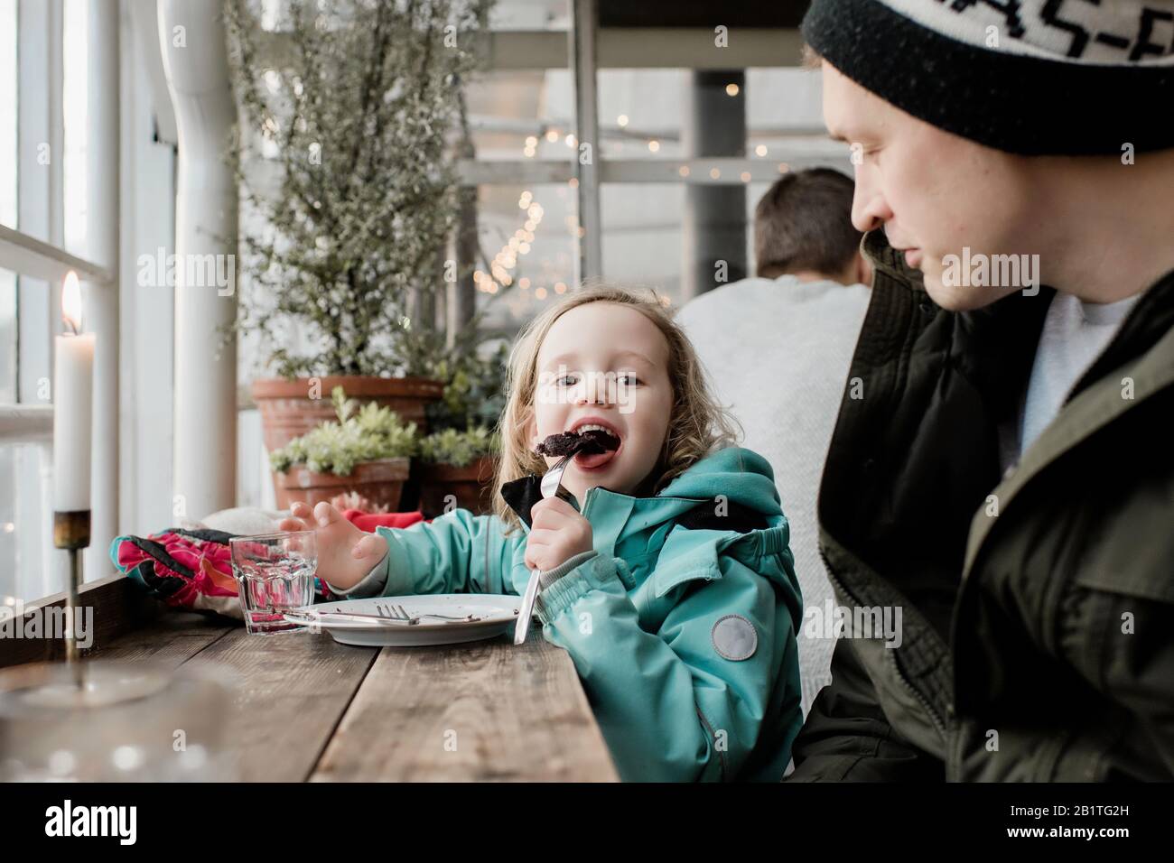 père et fille mangeant du gâteau au chocolat dans un café ensemble Banque D'Images