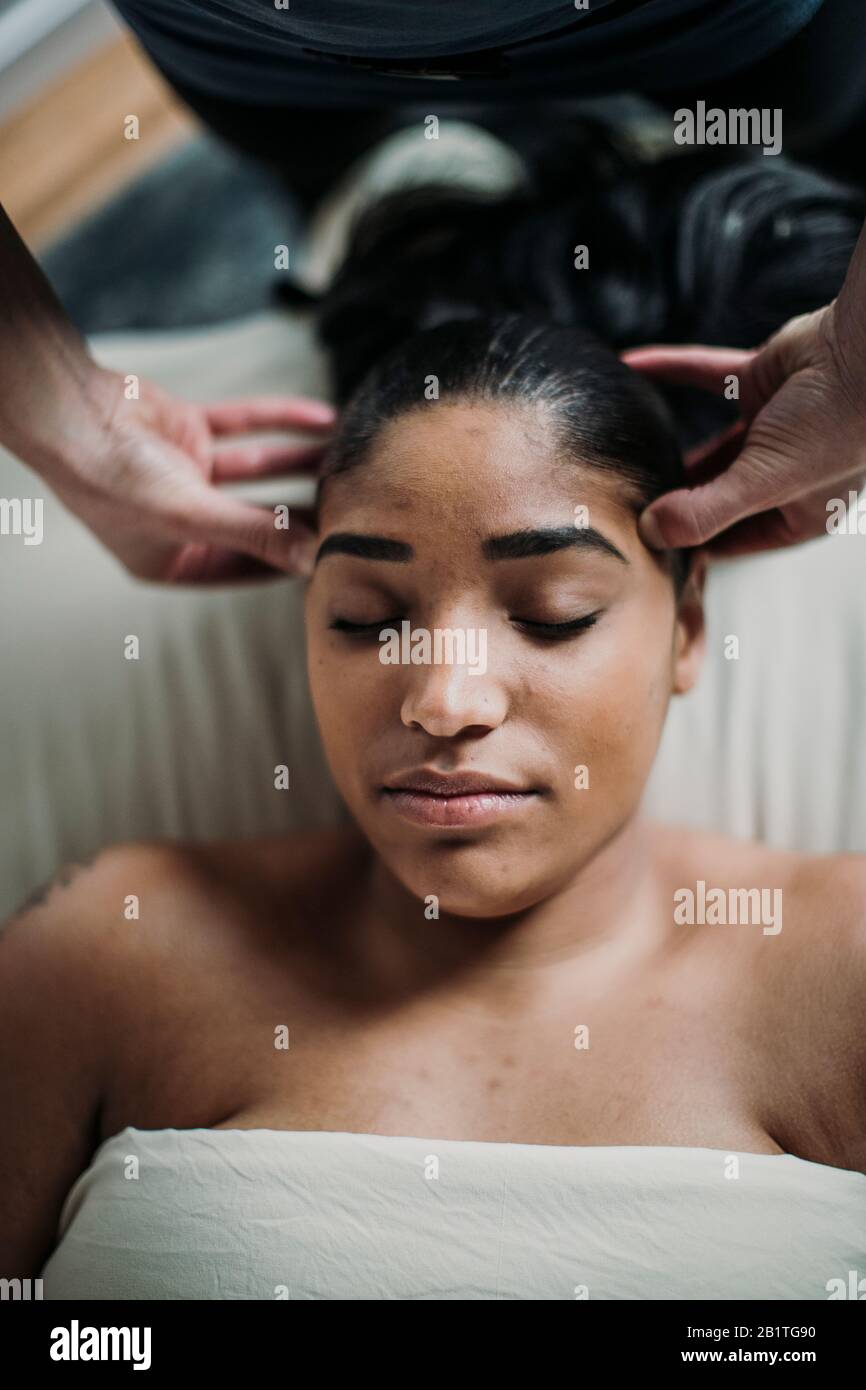 la femme afro-américaine reçoit un massage du cuir chevelu de la part d'un thérapeute Banque D'Images