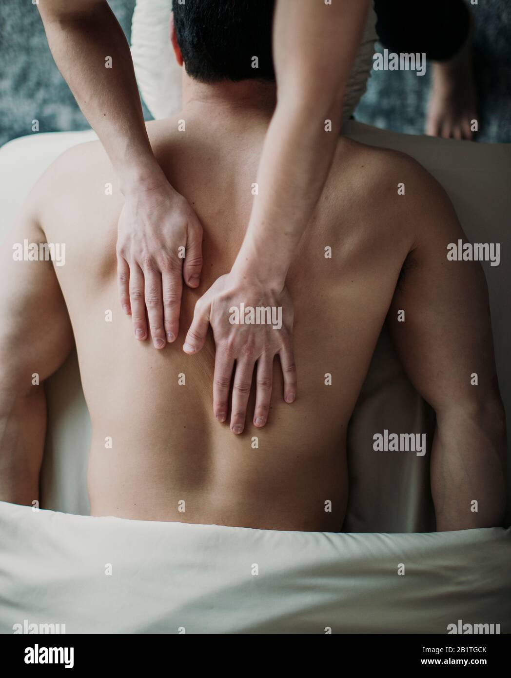 gros plan des mains de la femme sur le dos de l'homme sur la table de massage par le dessus Banque D'Images