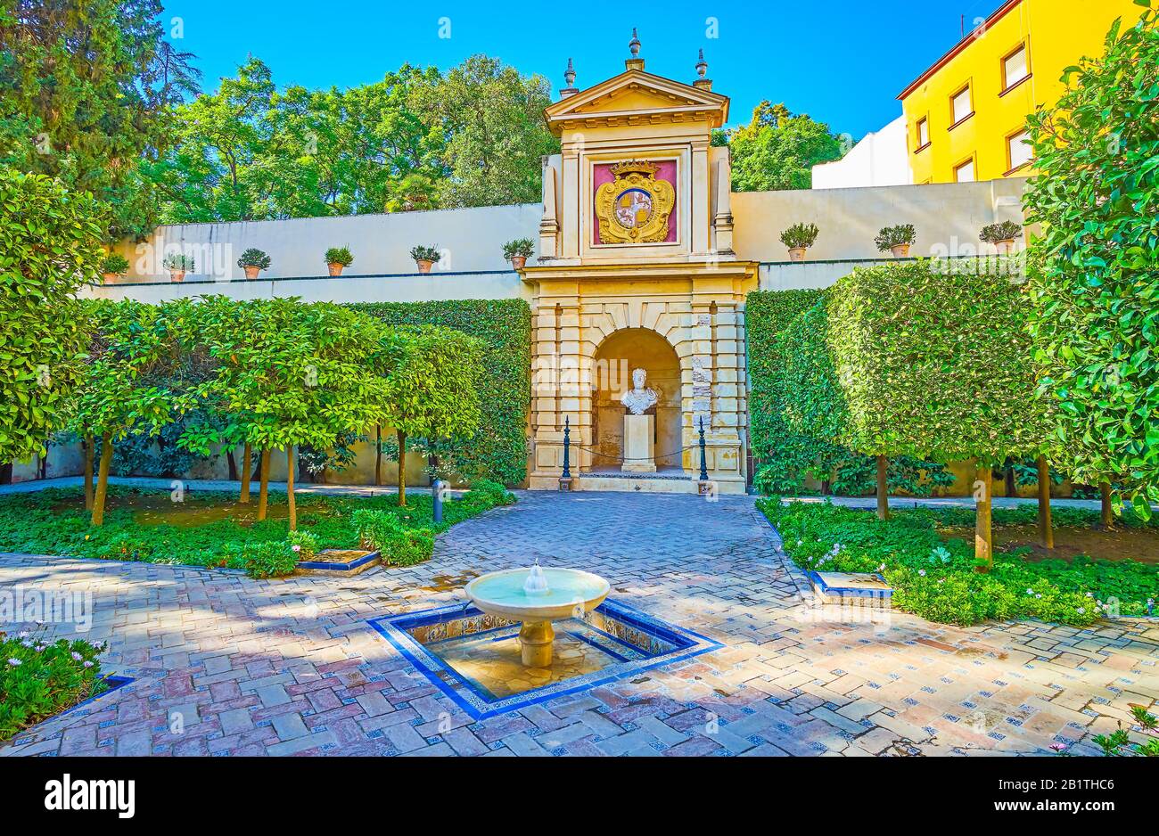 Séville, ESPAGNE - 1 OCTOBRE 2019: La cour du palais de l'Alcazar avec des plantes coupées, une petite fontaine et le buste du roi Pedro I et un manteau de bras Banque D'Images