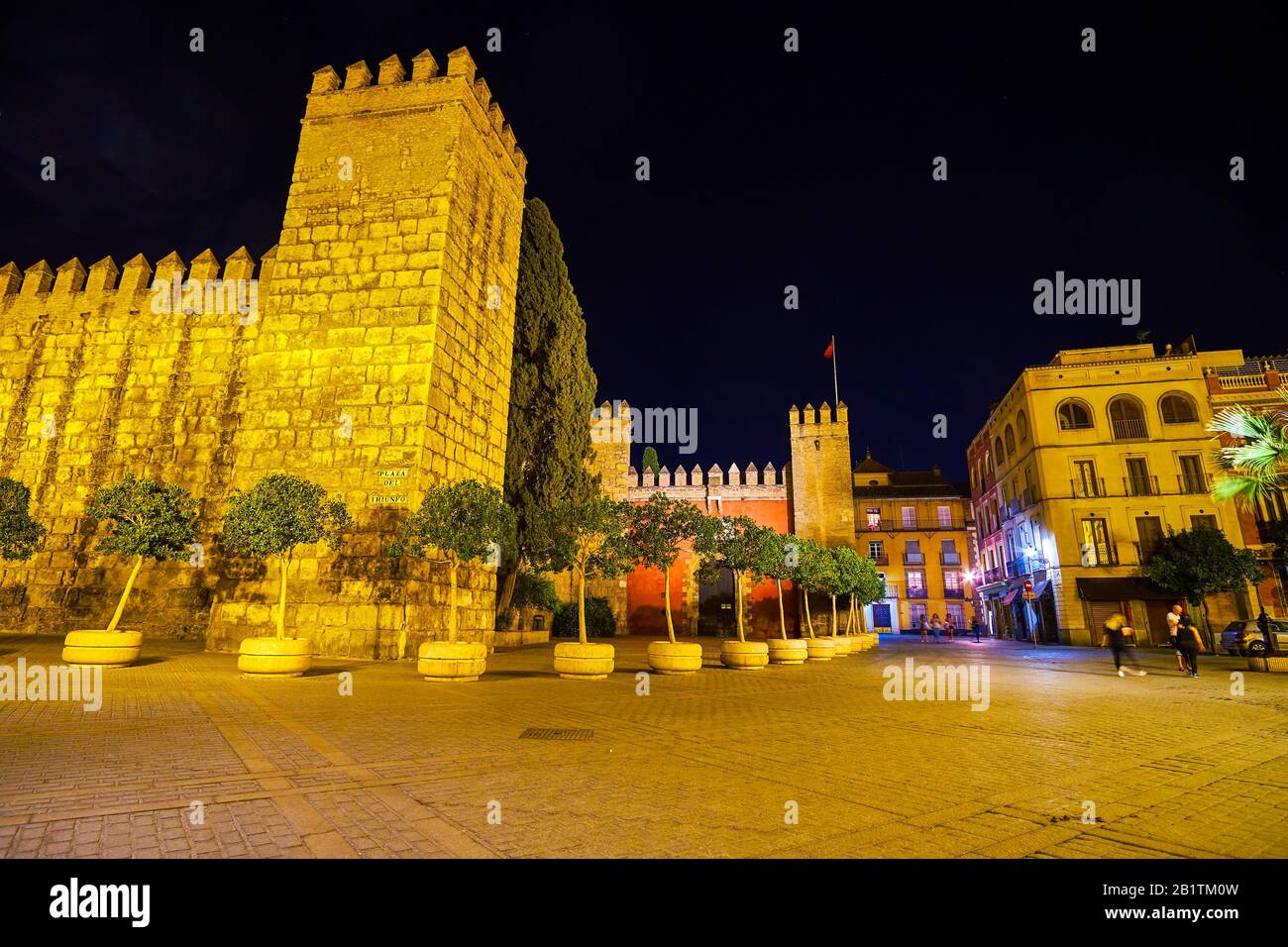 La vue nocturne sur la Puerta del Leon médiévale illuminée avec tour et murs du palais de l'Alcazar à Séville, Espagne Banque D'Images