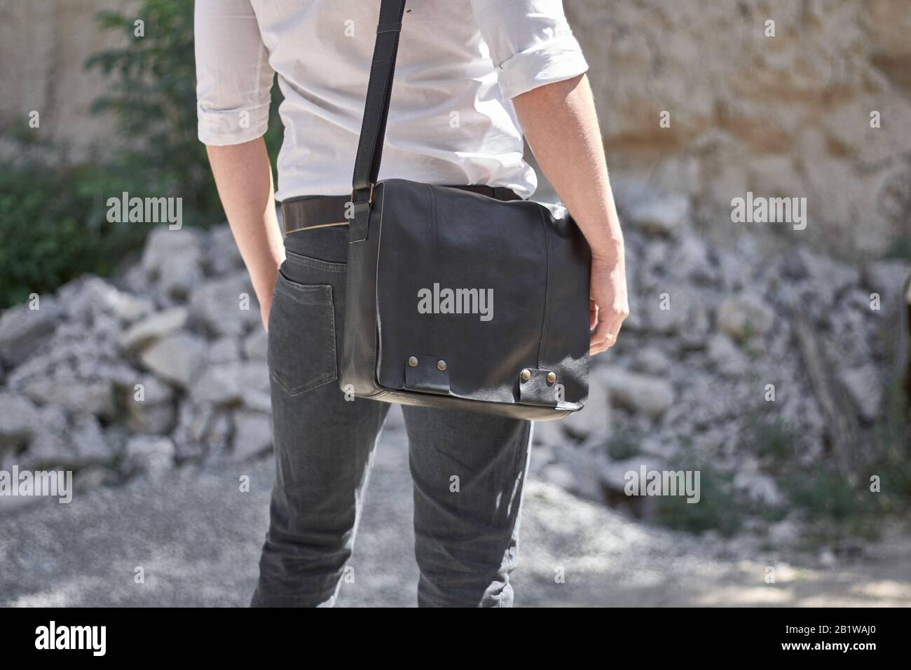 Homme avec un sac noir en cuir dans la rue. Banque D'Images