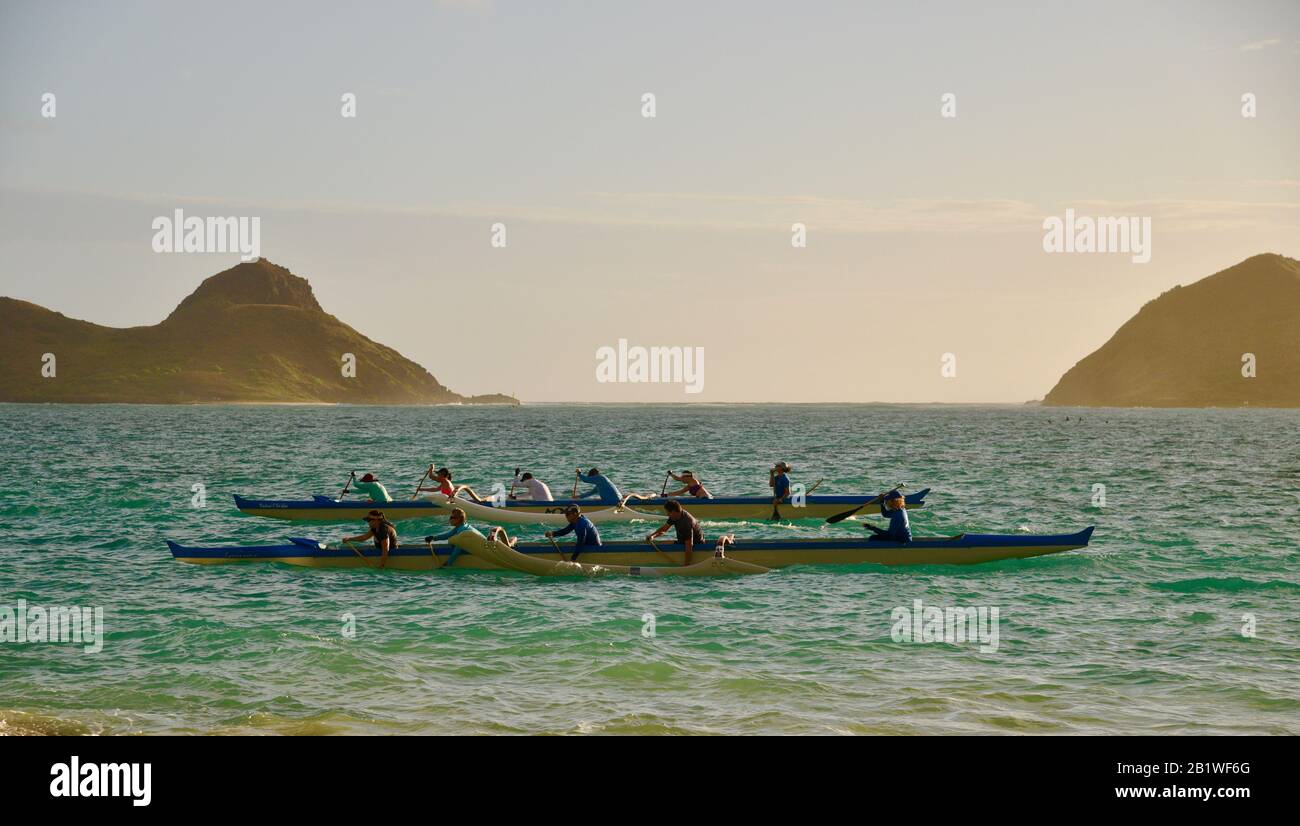 Les gens pagayant en canoë à l'outrigger dans les eaux turquoise au large de Lanikai Beach, Moku Nui île derrière (partie des îles Mokulua), Oahu, Kailua, Hawaï, États-Unis Banque D'Images