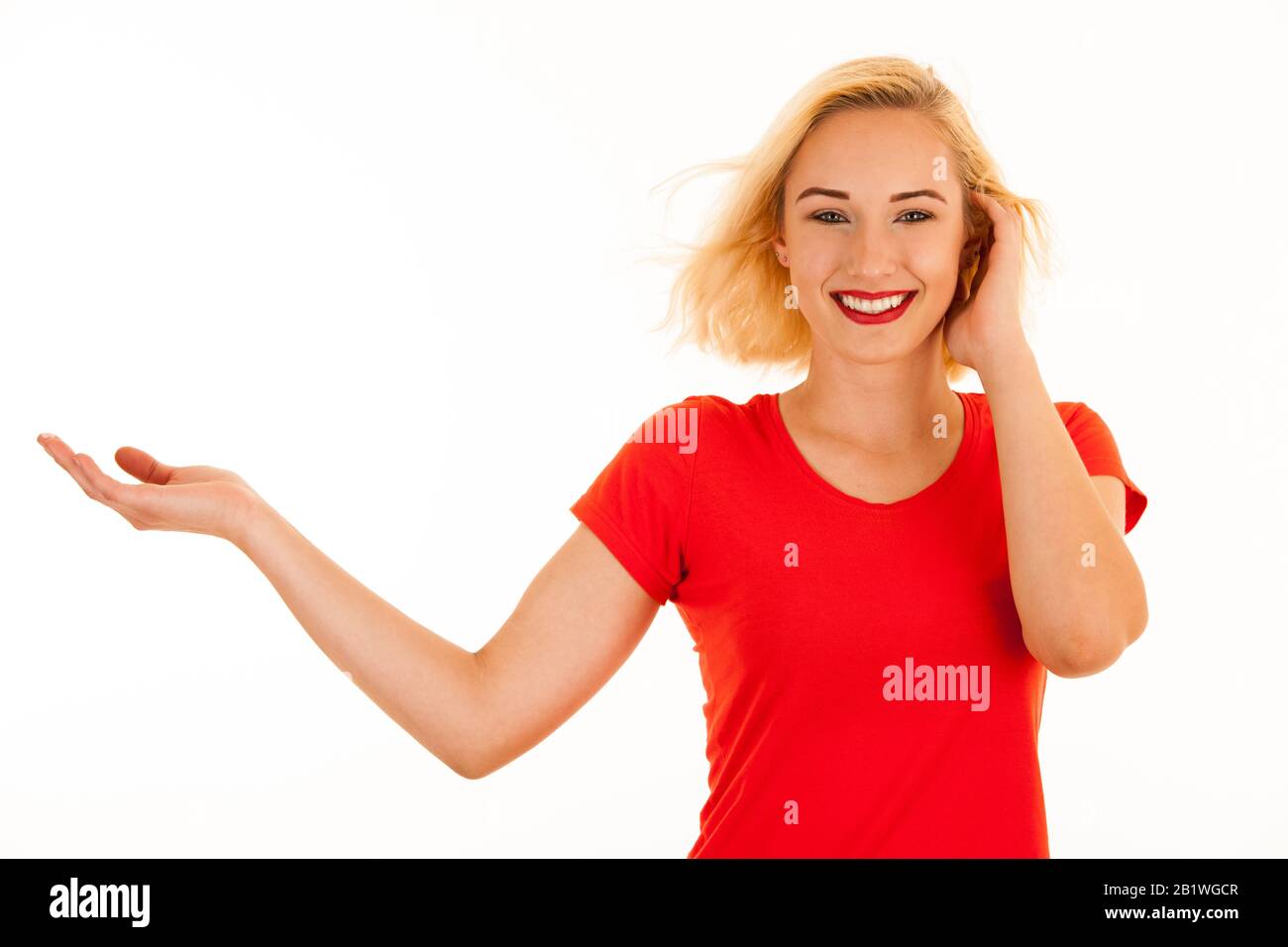 Belle jeune femme blonde attrayante pointant dans le copyspace lors de la publicité d'un produit Banque D'Images