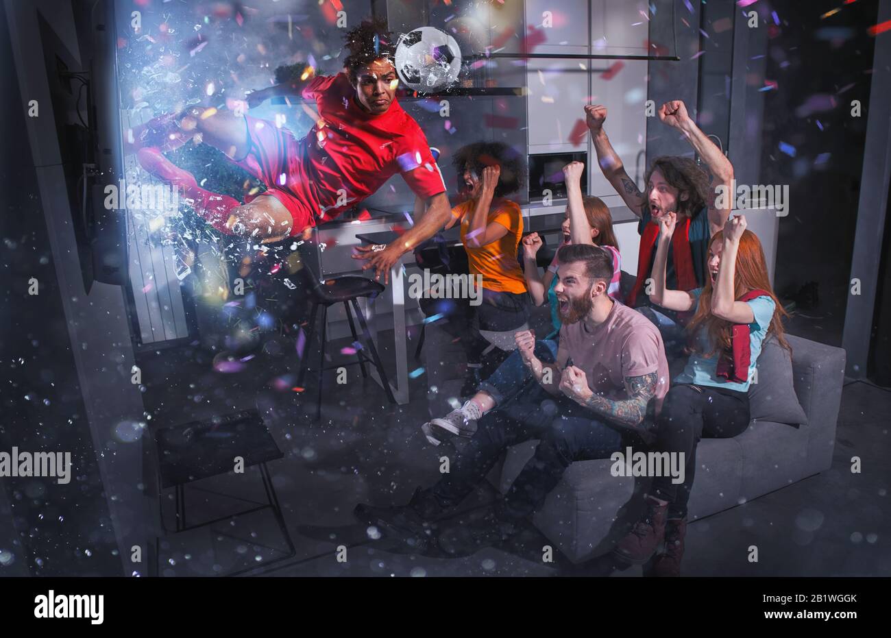 Un groupe d'amis regarde un match de football à la télévision avec un joueur de football qui sort de l'écran Banque D'Images