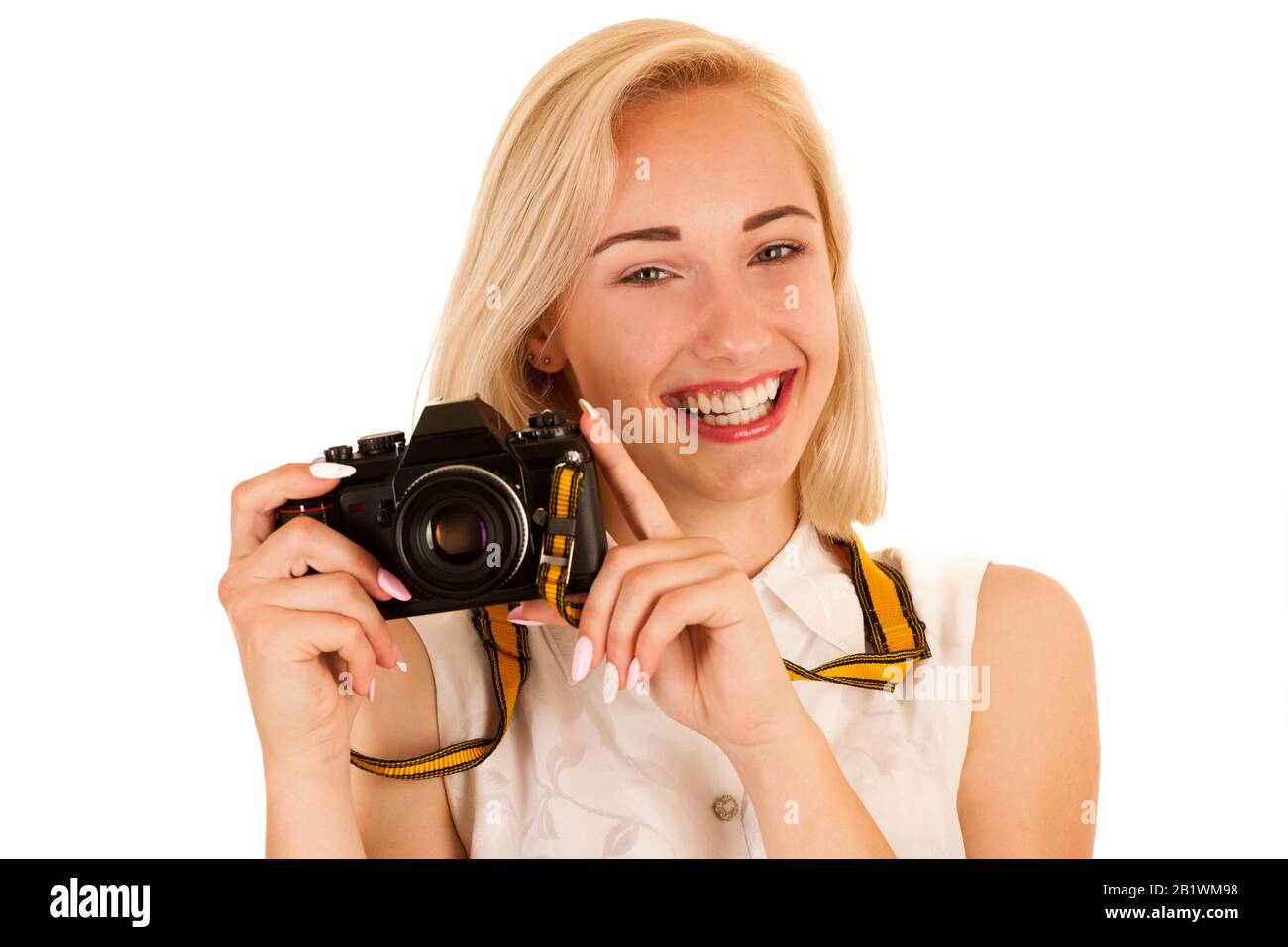 jeune femme active prenant des photos avec un appareil photo rétro isolé sur fond blanc Banque D'Images