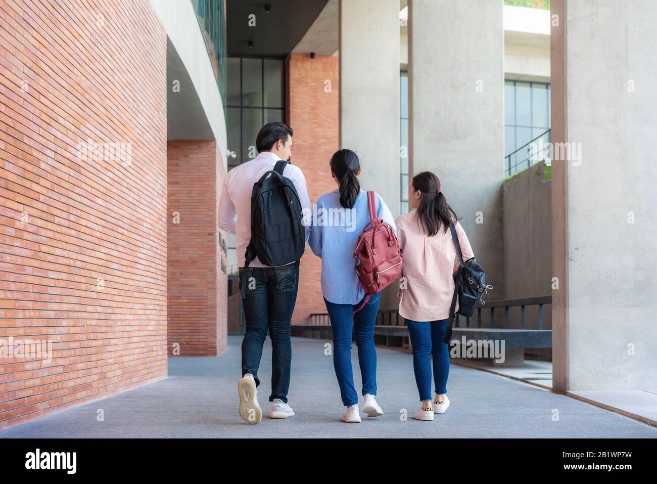 Asiatiques trois étudiants marchent et parlent ensemble dans le hall de l'université pendant une pause à l'université. Éducation, Apprentissage, Étudiant, Campus, Université, Banque D'Images