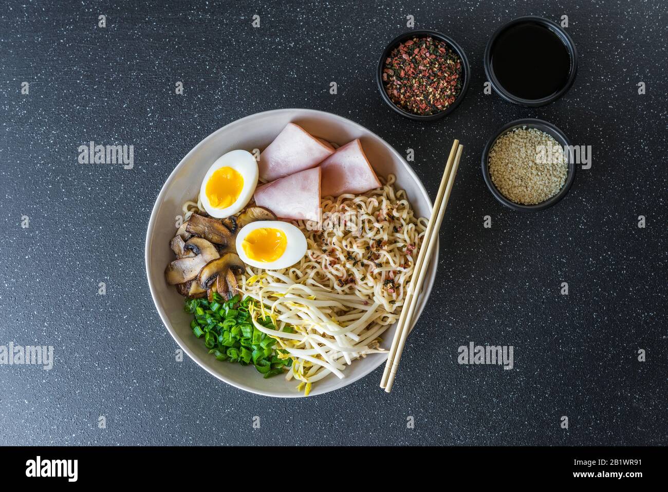 Un bol de ramen asiatiques nouilles soupe sur fond de pierre noire. Banque D'Images
