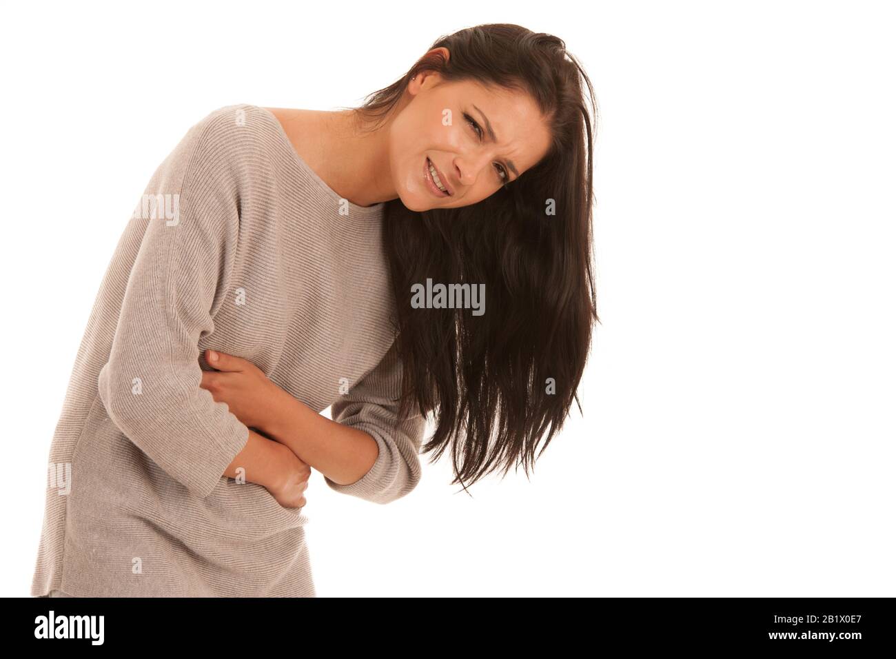 Jeune femme souffrant de maux d'estomac isolée sur fond blanc . Banque D'Images