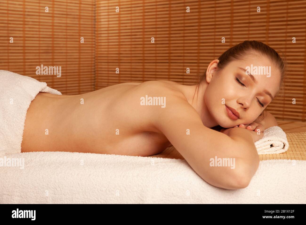 Belle jeune femme détendez-vous sur la table de massage dans le salon de spa . Banque D'Images