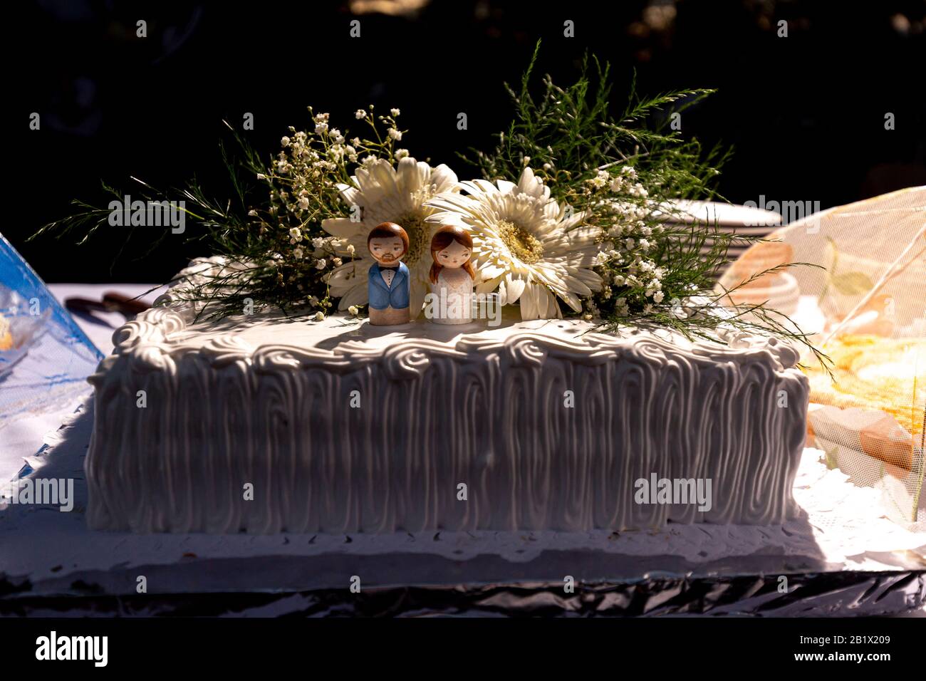Figurines Sur Un Gateau De Mariage Avec Bouquet De Fleurs Au Coucher Du Soleil Avec La Fete Hors Du Foyer En Arriere Plan Photo Stock Alamy