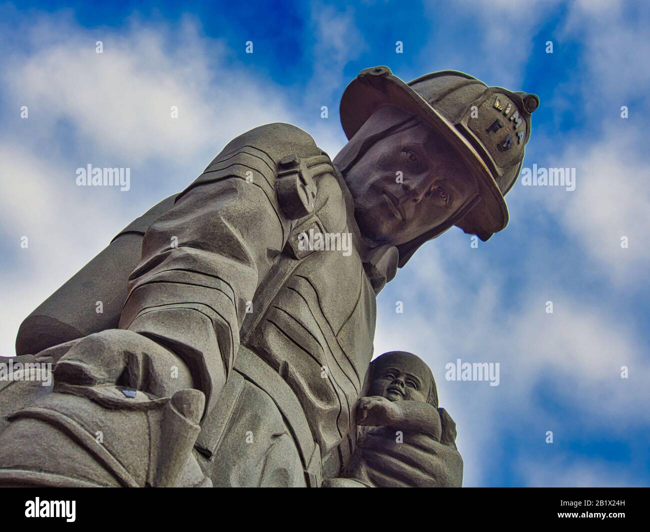 Pompier loi tenant un bébé avec le ciel bleu en arrière-plan à Lima Ohio États-Unis. Banque D'Images